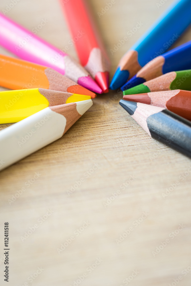 Obraz premium Color Pencils on wood texture. Macro shot of colorful pencils. Vertical view of pencils.