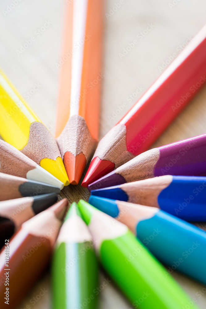 Obraz premium Color Pencils on wood texture. Macro shot of colorful pencils. Vertical view of pencils.