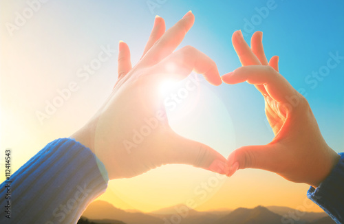 woman hand making love sign on the nature, nature background, Love nature concept, love to travel at nature, love nature symbol, mountain at nature.
