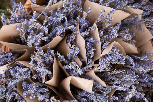 Fototapeta Naklejka Na Ścianę i Meble -  Top view on beautiful fresh lavender flowers in the basket on the street market. Bunches of lavender in craft paper. Romantic flowers.