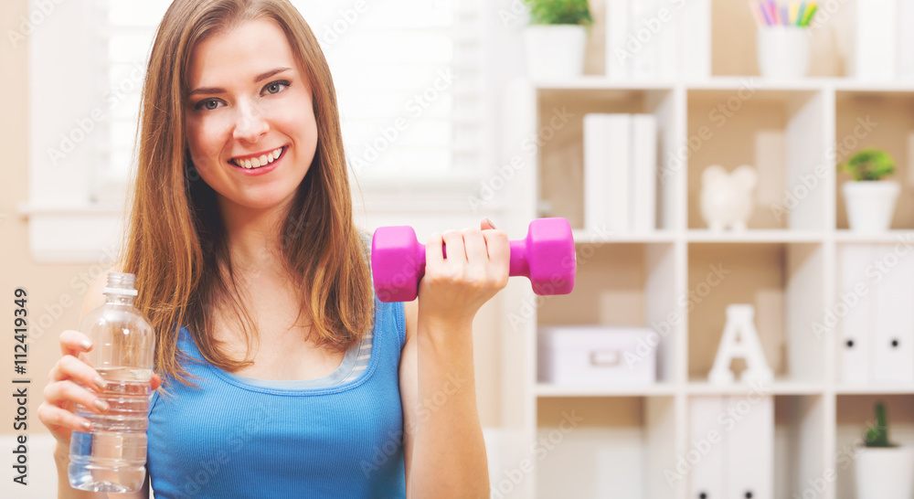 Happy young woman working out with dumbbells Happy young woman working out with dumbbells