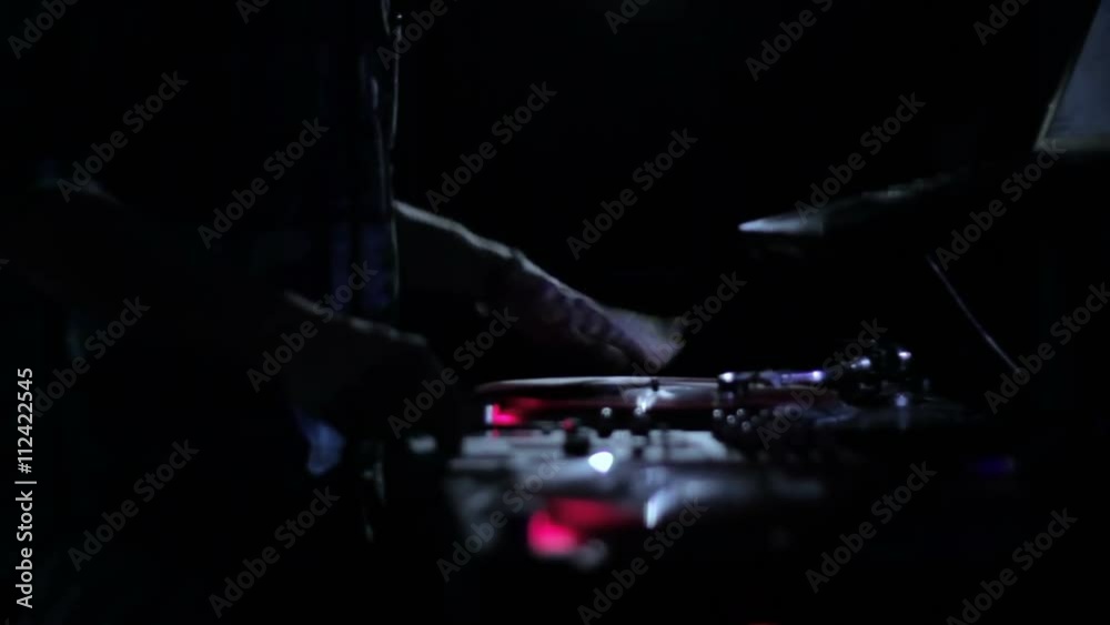 DJ scratching vinyl records and mixing on the Decks at a disco in Nightclub 7 DJ scratching vinyl records and mixing on the Decks at a disco in Nightclub 7