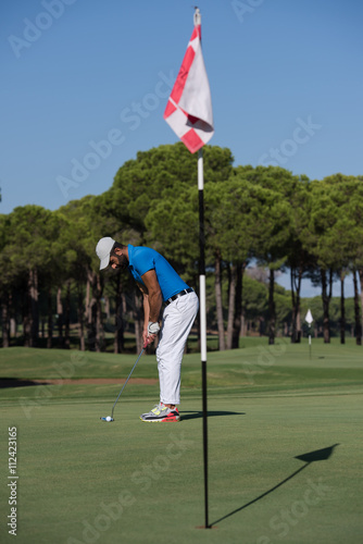 golf player hitting shot at sunny day