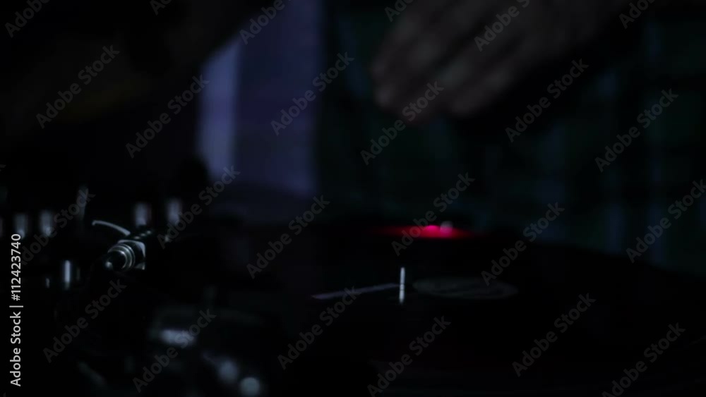 DJ scratching vinyl records and mixing on the Decks at a disco in Nightclub 17 DJ scratching vinyl records and mixing on the Decks at a disco in Nightclub 17