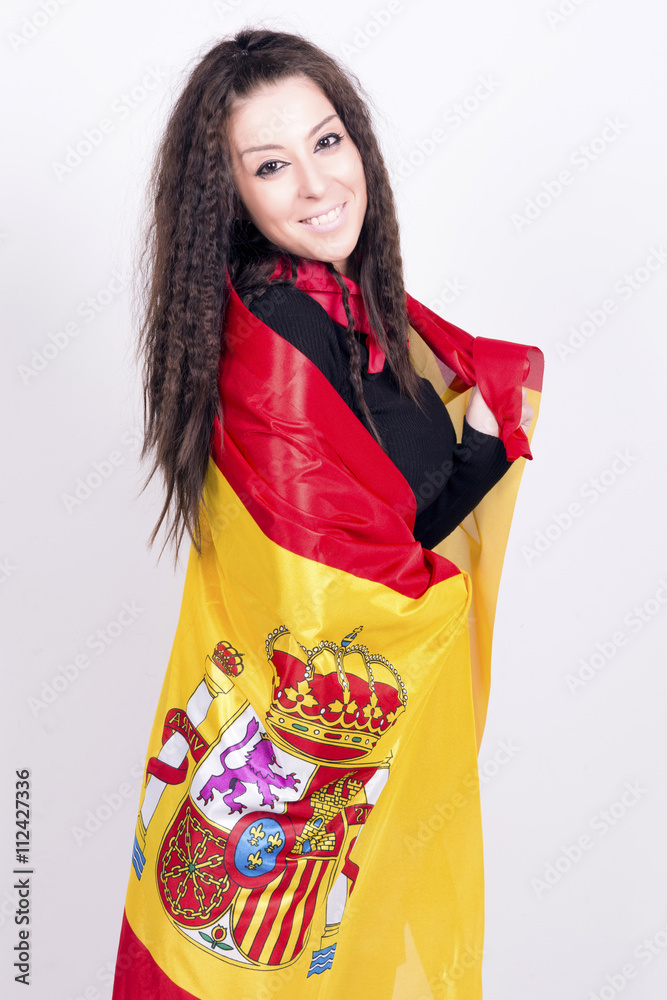 Woman playing with a spanish flag, wrapped in. She is a Spain team 