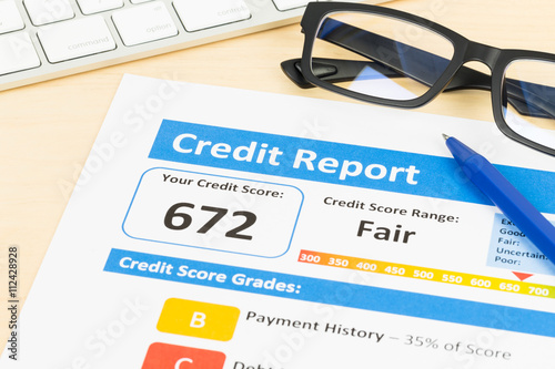 Fair credit score report with pen and keyboard; document is mock photo