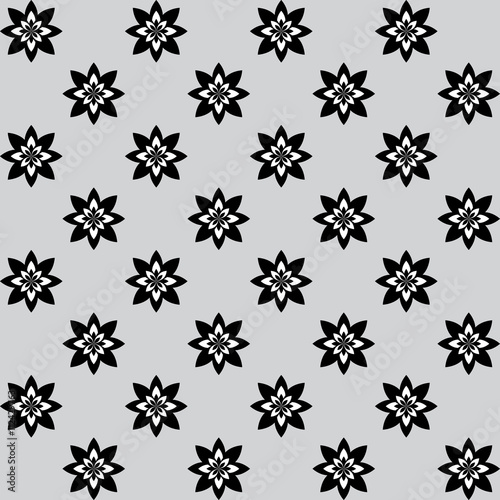 Floral pattern with alternate black and white flowers on grey background 