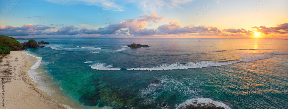 Obraz premium Panoramiczny widok tropikalna plaża z surfingowami przy zmierzchem.