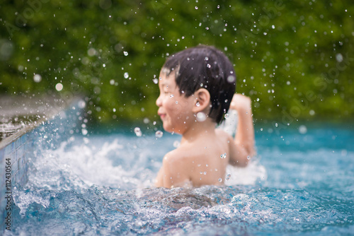 Asian child playing in swimming pool