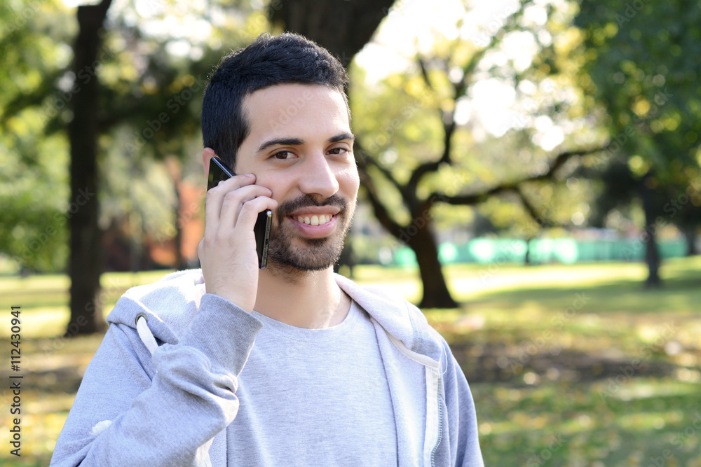 Young man talking on the phone. Outdoors. Young man talking on the phone. Outdoors.