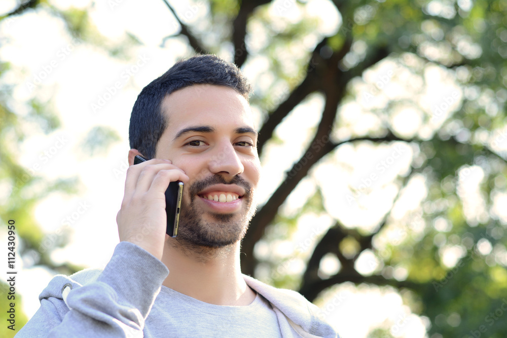 Young man talking on the phone. Outdoors. Young man talking on the phone. Outdoors.
