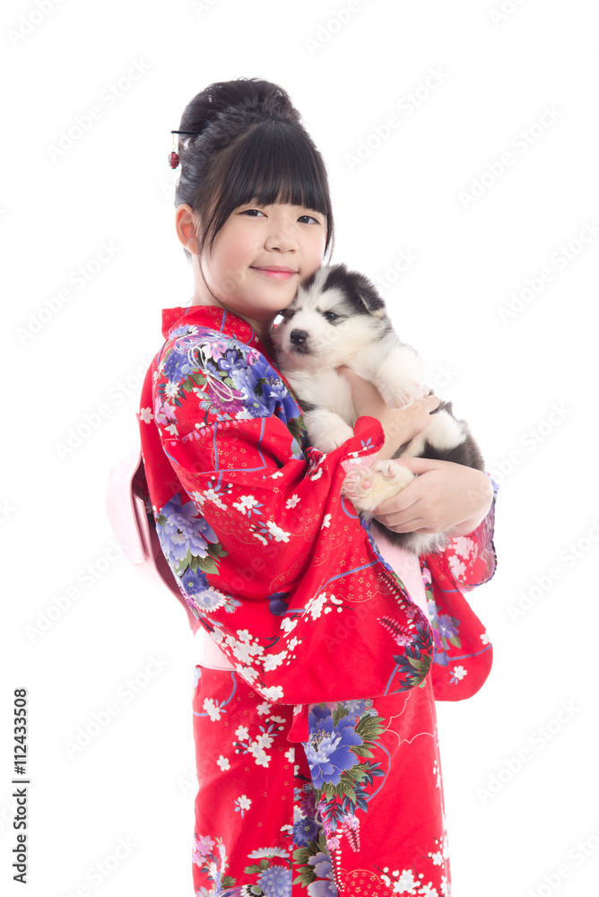 Little asian girl in red kimono playing with a siberian husky pu Little asian girl in red kimono playing with a siberian husky pu