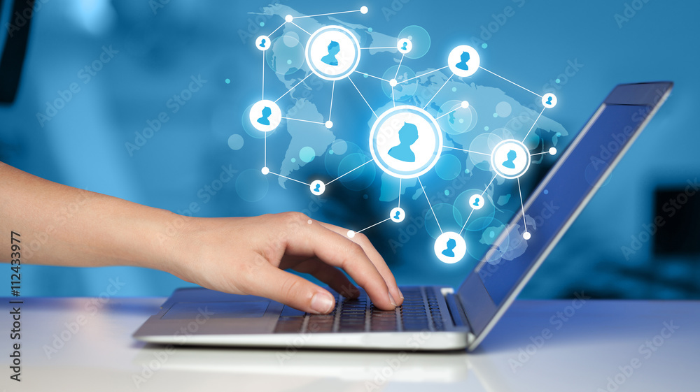 Close up of hand with laptop and social media icons Close up of hand with laptop and social media icons