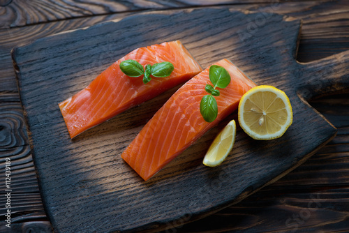 Obraz na plátně Rustic wooden chopping board with sliced smoked trout fillet