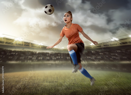 Female soccer player heading ball