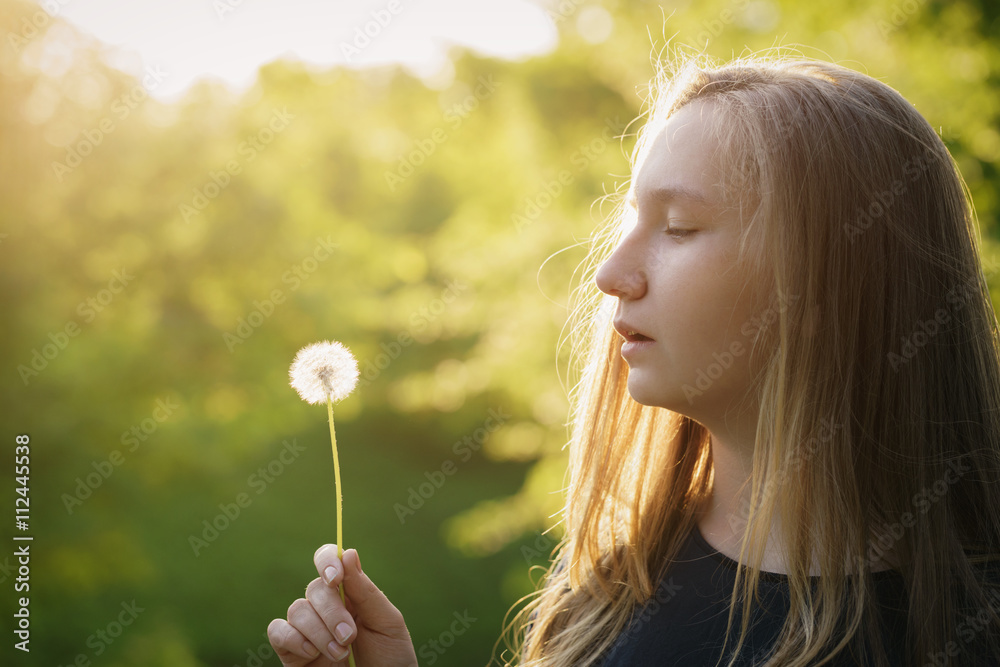teen girl ready to blow dandelion, side view teen girl ready to blow dandelion, side view