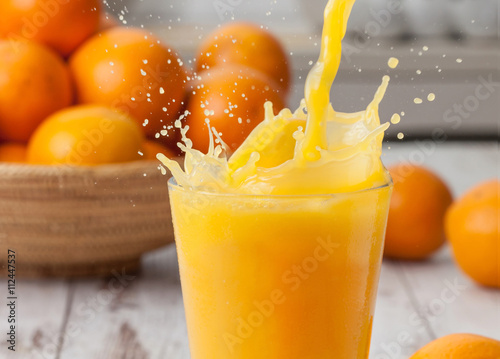 Photo Orange juice pouring splash