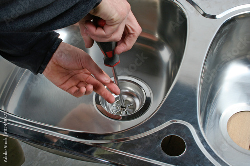 Canvastavla Plumber repairing kitchen sink