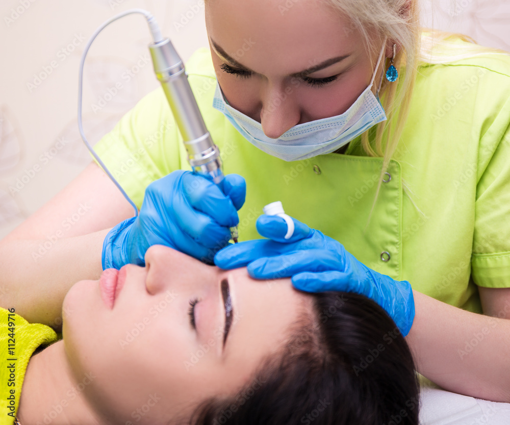 portrait of cosmetologist applying permanent make up on eyebrows portrait of cosmetologist applying permanent make up on eyebrows