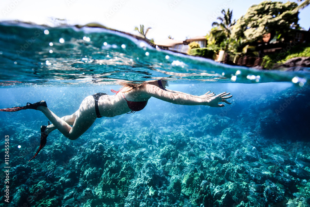 The woman in flippers and mask swims near coral. Photo underwater The woman in flippers and mask swims near coral. Photo underwater