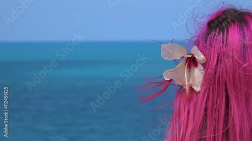 Girl with pink hairs looks at the sea from a height. Bermuda photo