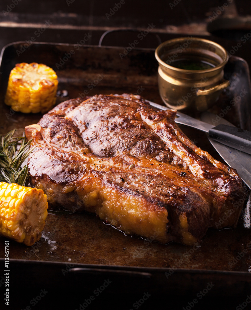 Grilled Black Angus Steak Ribeye  with rosemary and corn on iron