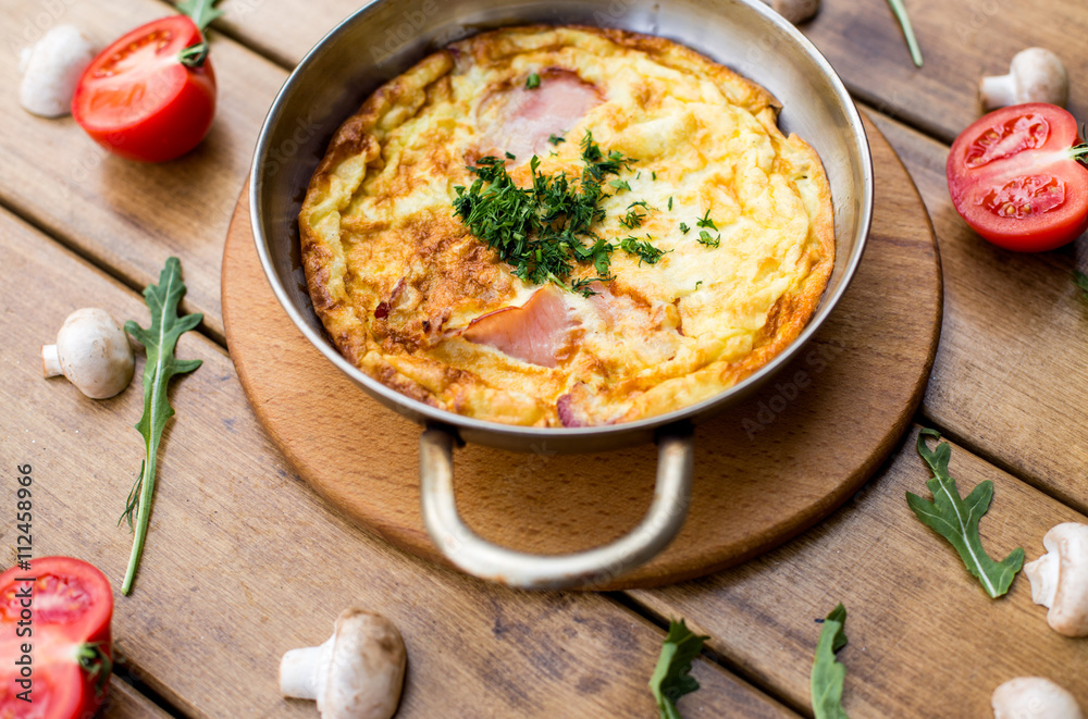 Omelet with tomatoes, parsley and feta cheese in pan. Top view
