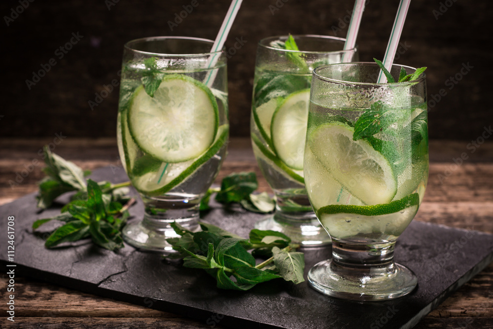 Fototapeta premium detox water with a lemon, lime and mint on a wooden table