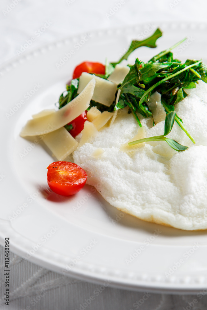 Fluffy Egg White Omelette with rukola, cheese and cherry tomatoes. White dish. Without yolk. Fluffy Egg White Omelette with rukola, cheese and cherry tomatoes. White dish. Without yolk.