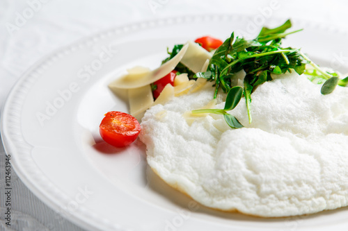 Fluffy Egg White Omelette with rukola, cheese and cherry tomatoes. White dish. Without yolk.