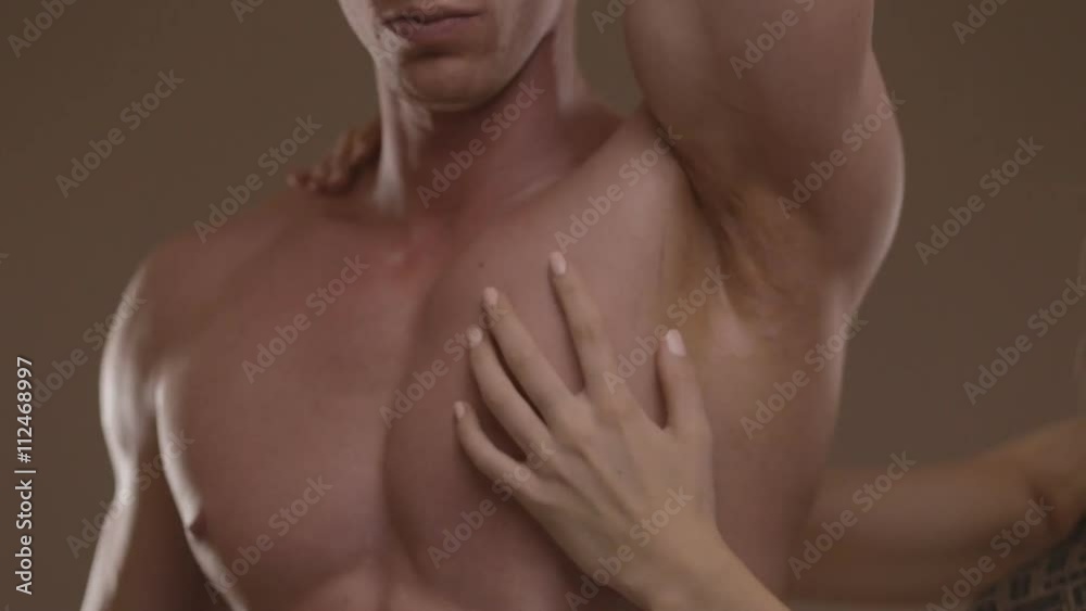 Hands of young woman touching athletic torso with abs of man. Ungraded Hands of young woman touching athletic torso with abs of man. Ungraded