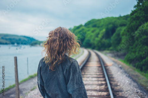 Young woman walking on railroad tracks