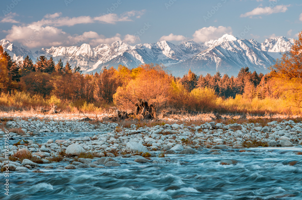 Naklejka premium Beautiful autumn panorama over Bialka river to snowy Tatra mountains, Poland - focus on water and stones