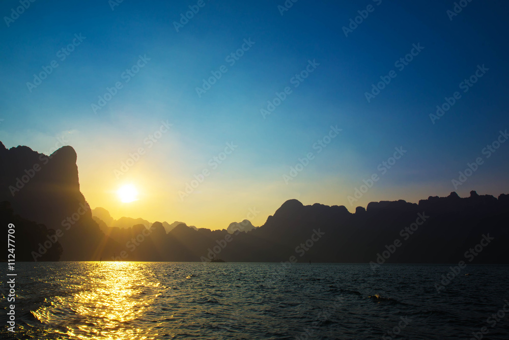 Sunset behind mountain and blue sky at Khaosok Lake