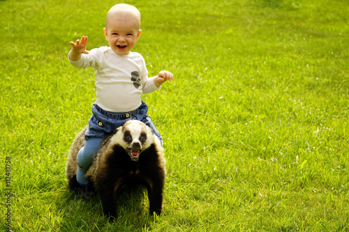 Obraz na plátne small boy sits astride a scarecrow badger