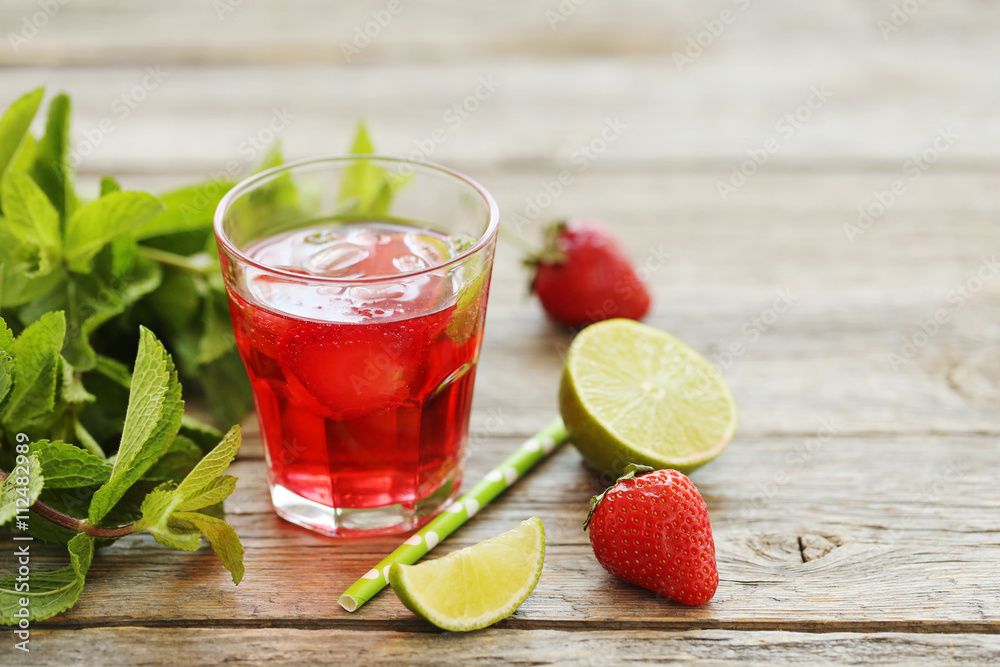 Fresh strawberry drink in glass with lime on wooden table Fresh strawberry drink in glass with lime on wooden table