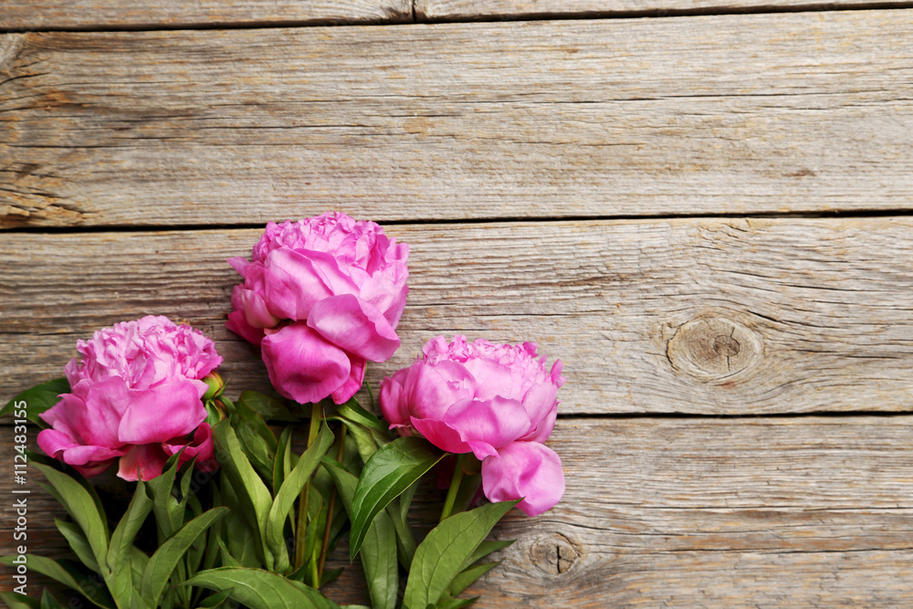 Bouquet of pink peony flowers on wooden table
