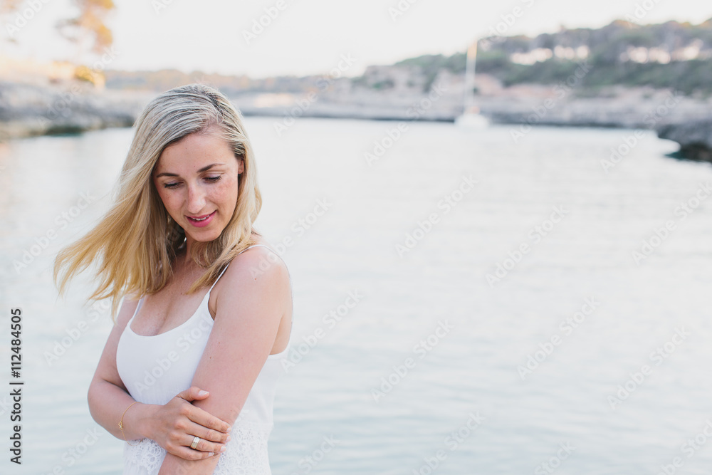 Grinning woman in long dress standing near water Grinning woman in long dress standing near water