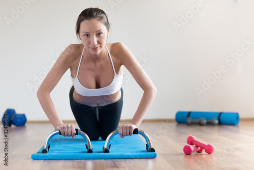 Woman doing training with abs roller wheel.