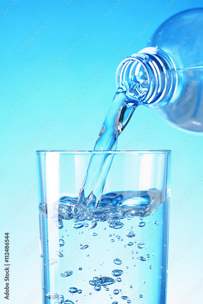 Water poured from a bottle into a glass Water poured from a bottle into a glass