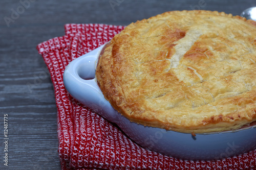 Chicken and bacon pot pie with cheese on wooden table