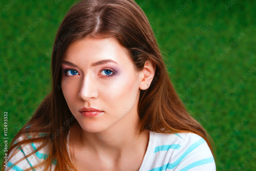 Beautiful young woman sitting on the green grass Beautiful young woman sitting on the green grass