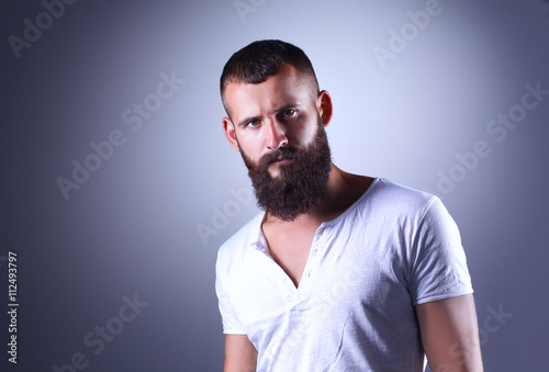 Portrait of handsome man standing, isolated on grey background