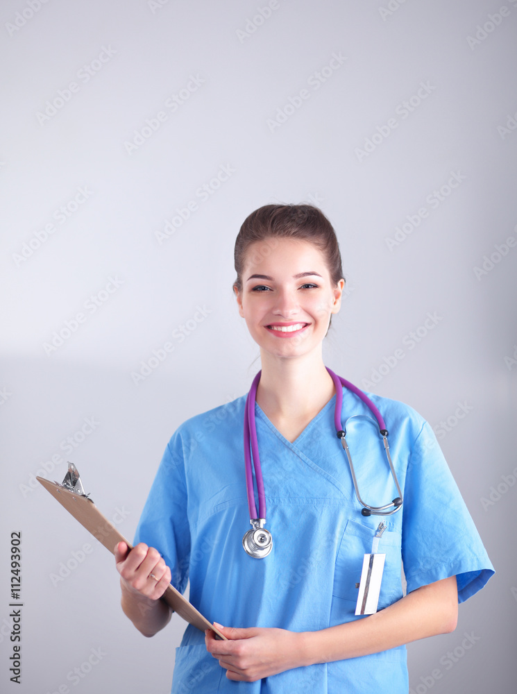 Smiling female doctor with a folder in uniform standing at hospital Smiling female doctor with a folder in uniform standing at hospital
