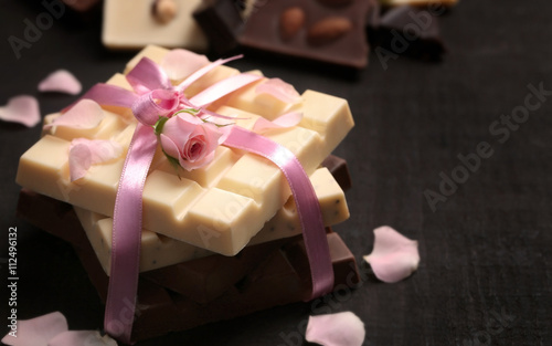 Chocolate tied with pink ribbon on black background