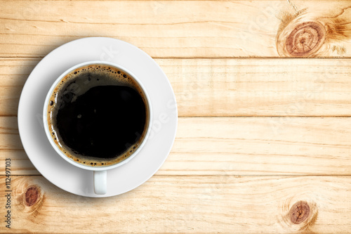 Top view of coffee cup on a wood background with copy space.