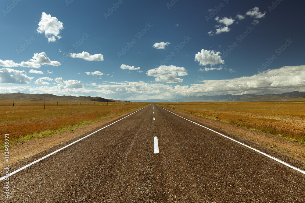Straight road goes to horizon on background of sky and mountains. Altay mountains, Siberia, Russia. Straight road goes to horizon on background of sky and mountains. Altay mountains, Siberia, Russia.