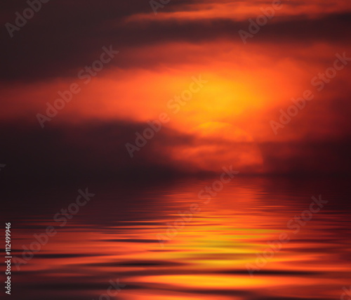 Fiery sunset with reflection in water
