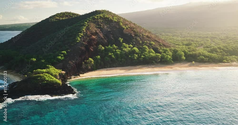 Aerial view flying over tropical white sand beach at sunrise