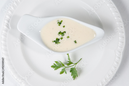 Tasty Bechamel sauce or white sauce with fresh greenery